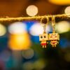 two man and woman wooden couple keychains hanging on rope overlooking bokeh lights